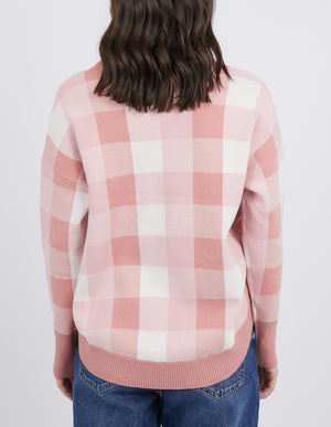 A person with shoulder-length brown hair wears the Foxwood Julissa Crew in pink and white checks and blue jeans, standing against a plain background, viewed from behind.
