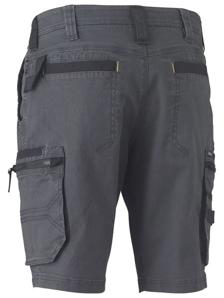The Bisley Flex & Move Stretch Utility Cargo Short is designed for durability and comfort, featuring multiple pockets, including two rear pockets, a zippered side pocket, and a cargo pocket with a flap on the left thigh. These gray work shorts also boast reinforced belt loops and stitching details.