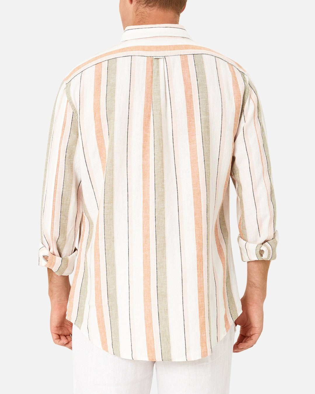 A man is seen from the back wearing the Industrie The Orchard Linen Shirt, a 100% linen, long-sleeve, button-up shirt featuring vertical stripes in pastel colors such as beige, peach, and olive green. The sleeves are rolled up to his elbows. He is also wearing white pants. The background is plain white.