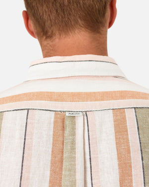 A person with short hair is wearing the Industrie The Orchard Linen Shirt, which has long sleeves and features vertical stripes in beige, green, orange, and white tones. Made from 100% linen, the focus is on the back of the person and the shirt, highlighting its pattern and texture against a plain white background.