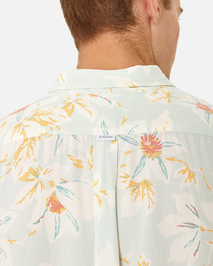 A person faces away, donning the Industrie The Esperanza Shirt—a comfy, floral-patterned casual shirt in pastel yellow, pink, and blue. Made from 100% Rayon in a classic fit, it has a small embroidered "Indochino" tag on the back. The backdrop is plain white.