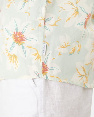 Close-up of Industrie The Esperanza Shirt in light green, classic fit, with a vibrant yellow, orange, and teal floral pattern. Made from 100% Rayon with a side seam tag, its lightweight fabric offers comfort and style when paired beautifully with white pants for a casual look.