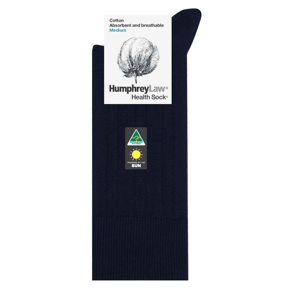 Image featuring a navy blue Humphrey Law Pure Cotton Sock with labeling. The label at the top reads "Humphrey Law® Health Sock™" and "Cotton Absorbent and breathable Medium." The sock has a small triangular logo that indicates Australian origin and a sun symbol denoting UPF 50+ sun protection.