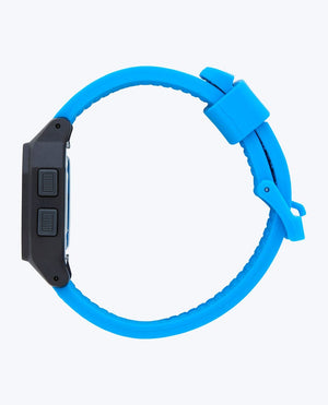 The Rip Curl Atom Digital Watch features a bright blue silicone strap, a black rectangular face, and waterproof durability, shown in side view against a light background.
