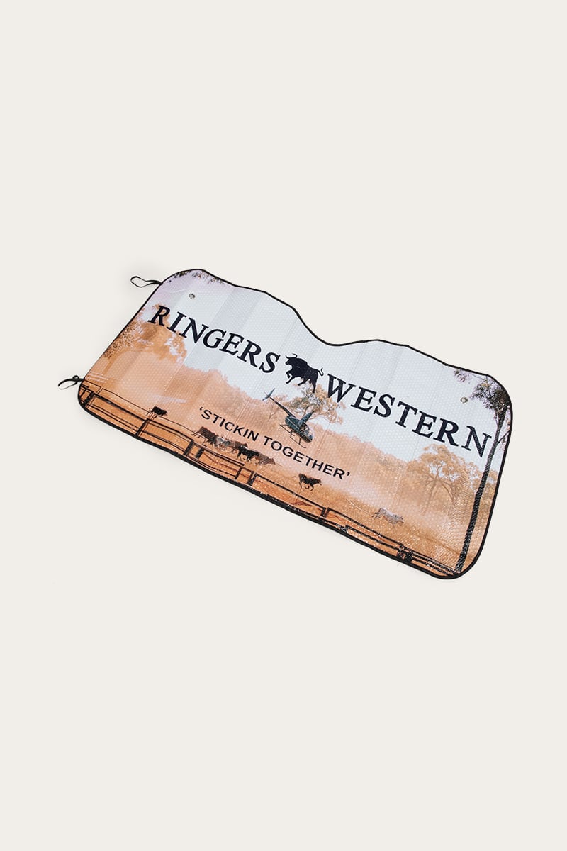 The Ringers Western Eclipse Car Windscreen Shade showcases a captivating sunset landscape with two cowboys. The text "Ringers Western" is displayed at the top, while "Stickin' Together" is written at the bottom. This striking car sunshade primarily features light brown and white colors, accented with black outlines and details.