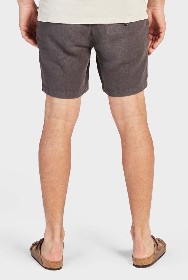 A person is shown from behind wearing a beige shirt, relaxed-fit Academy Brand Riviera Linen Shorts in gray with an elastic waist, and brown sandals, all set against a white background.