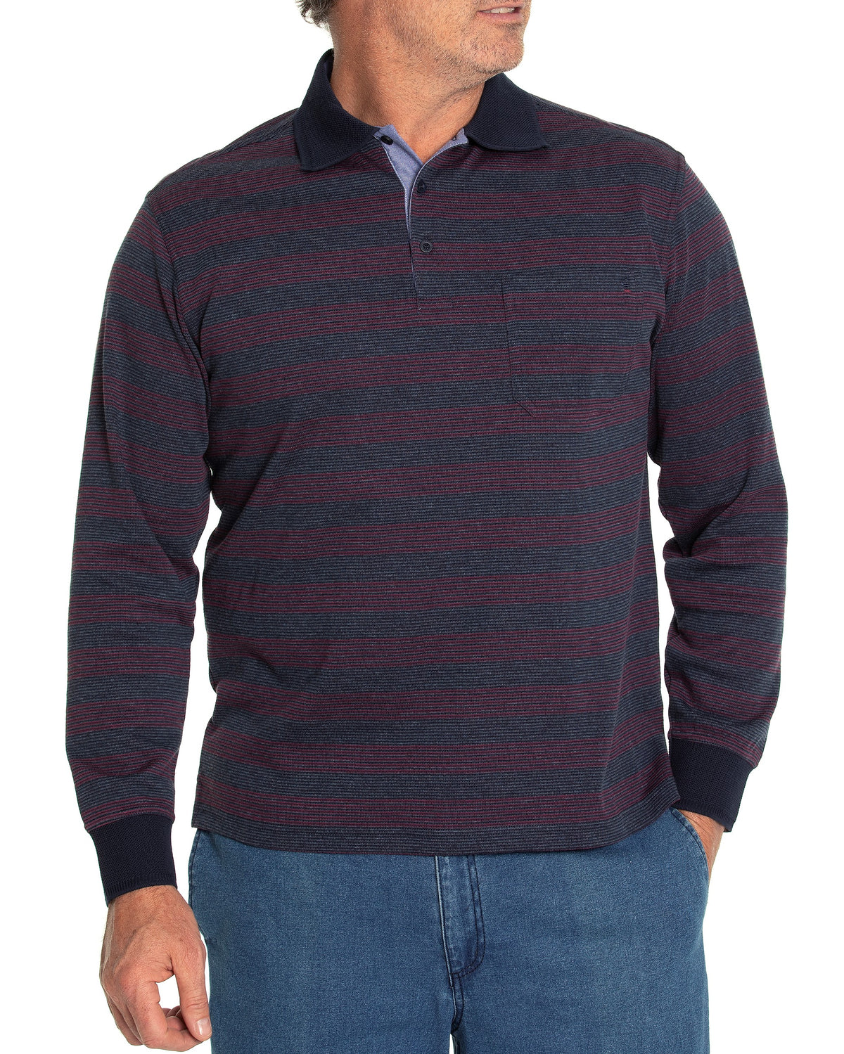 A man is showcasing the Breakaway Lars Micro Prima Polo, a stylish long-sleeve shirt featuring dark blue and maroon stripes, an open pocket on the left chest, and ribbed cuffs. He has paired it with blue jeans. One hand is in his pocket as he stands against a white background.