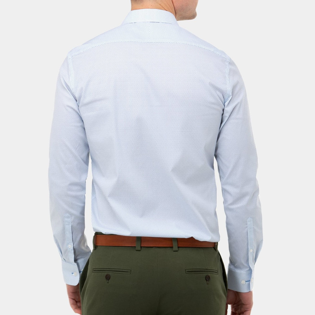 A person is seen from behind wearing a light blue, long-sleeved Brooksfield Stretch Print Shirt with a subtle dotted pattern, olive green trousers featuring two back pockets with buttons, and a brown belt. The background is plain white.