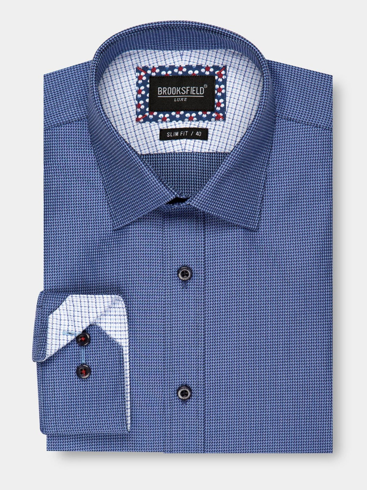 A stylish, folded long-sleeve, blue checkered dress shirt with a contrasting white and blue interior pattern. Made from 100% cotton, the "Brooksfield Luxe Textured Shirt" label at the collar inside indicates a slim fit and size "40". The shirt is finished with dark buttons for an elegant touch.