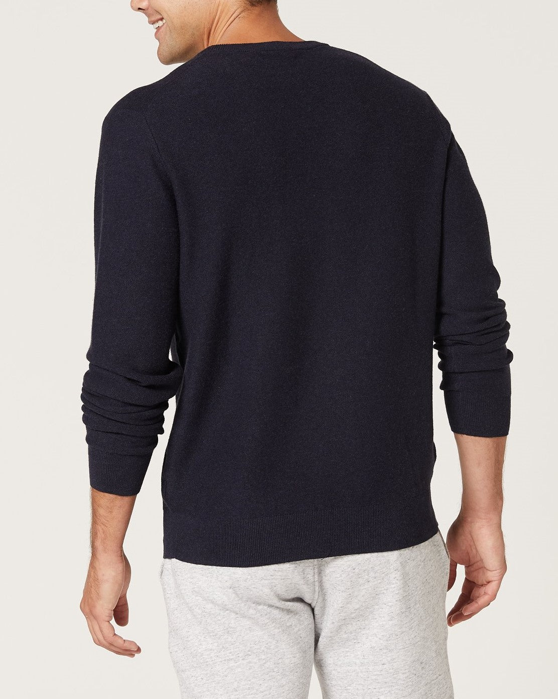 A man is seen from the back wearing the Blazer Mason Cotton Crew Neck jumper in dark color with light gray pants, standing against a plain light background. The jumper is made from 100% cotton.