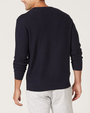 A man is seen from the back wearing the Blazer Mason Cotton Crew Neck jumper in dark color with light gray pants, standing against a plain light background. The jumper is made from 100% cotton.
