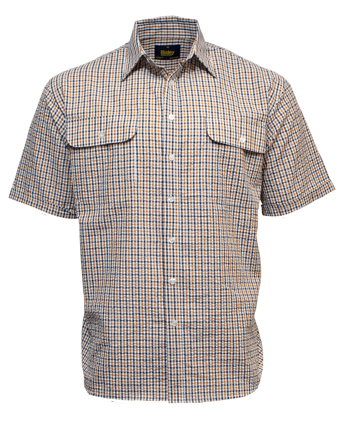 The Bisley Countryman Seersucker Short Sleeve Shirt is a button-up, short-sleeve shirt with a checkered pattern in shades of blue, white, and tan. It features two buttoned chest pockets with flaps and a collar. Made from a Polyester/Cotton blend, the label on the collar reads "Bisley.