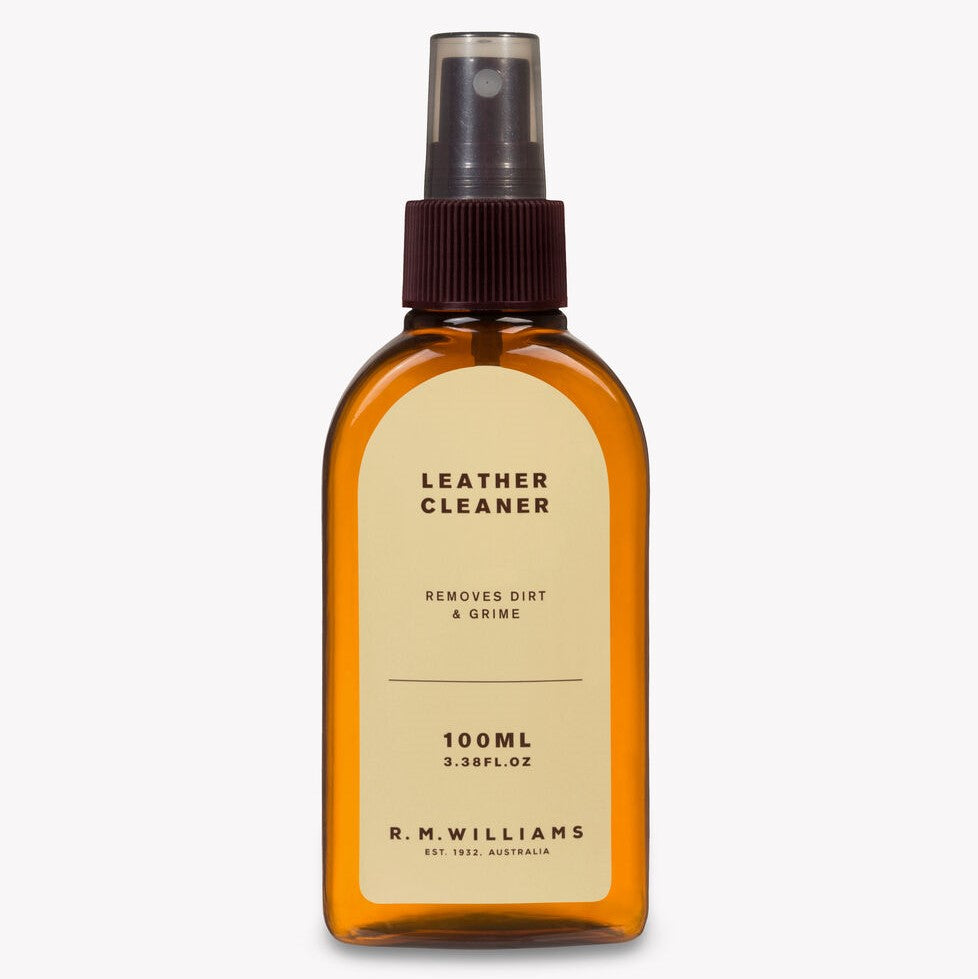 A 100ml bottle of RM Williams Leather Cleaner with a nozzle spray top. The label states "Leather Cleaner Removes Dirt & Grime" and includes volume information. The amber-colored bottle features a brown cap, perfect for maintaining your leather items in pristine condition.