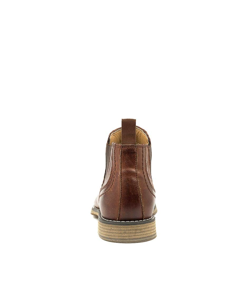 Rear view of the Colorado Mills Boot, a brown leather Chelsea boot featuring a pull tab and a light brown stacked heel, ideal for any men's boot collection, displayed against a plain white background.