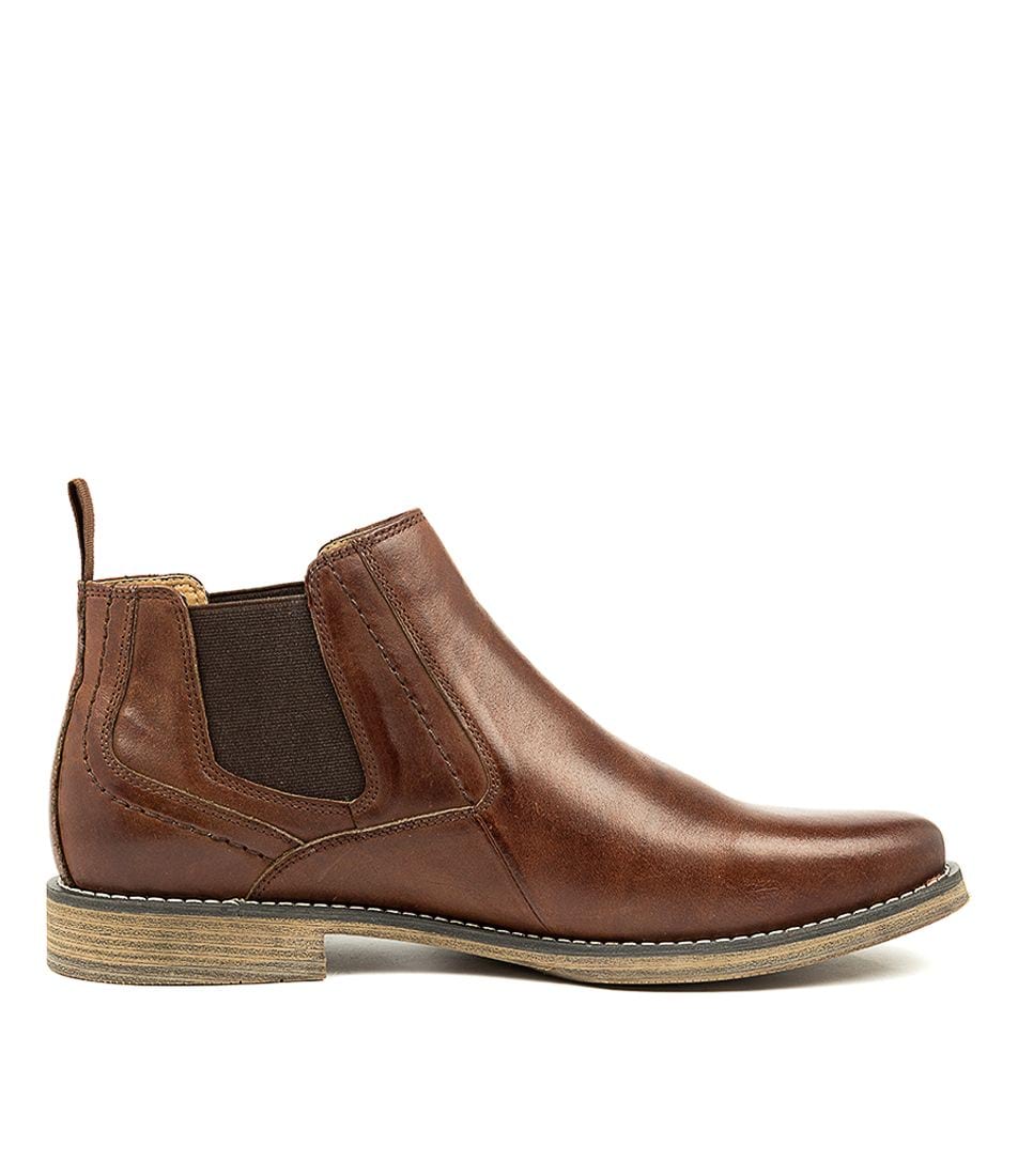 A side view of the Colorado Mills Boot, a men's brown leather Chelsea boot featuring elastic side panels, a wooden sole, a back pull tab, and detailed edge stitching for a timeless style.