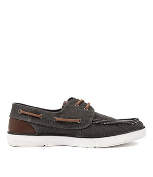 The Colorado Ailon Canvas shoe boasts a dark gray canvas with brown leather accents. It includes white stitching, a white rubber sole, brown laces, and a slip-on moc-toe design for easy wear.