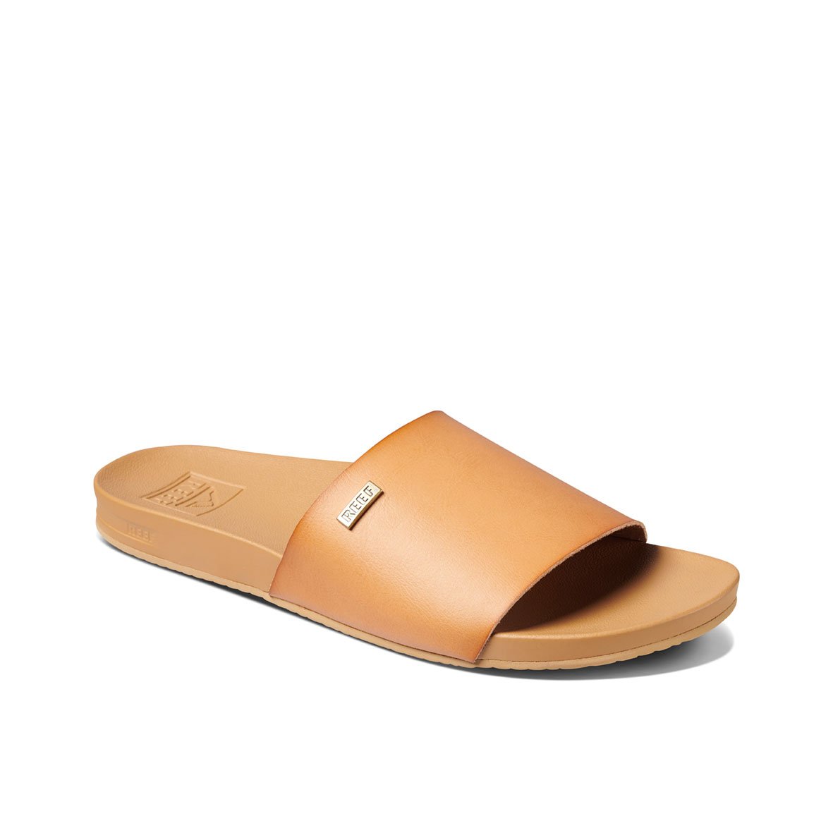 The REEF Cushion Scout is a tan-colored slide sandal with a single wide strap across the top. It features a contoured footbed and cushion bounce midsole for ultimate comfort, along with an arch-support heel cup. The strap includes a small branding tag, and the flat sole has a textured surface for enhanced grip.