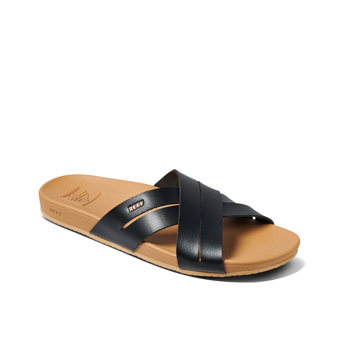 The REEF Cushion Spring Bloom sandal features a tan footbed with black crisscross leather straps and a small "REEF" logo. It offers supportive arch support for comfort and a textured sole for grip.