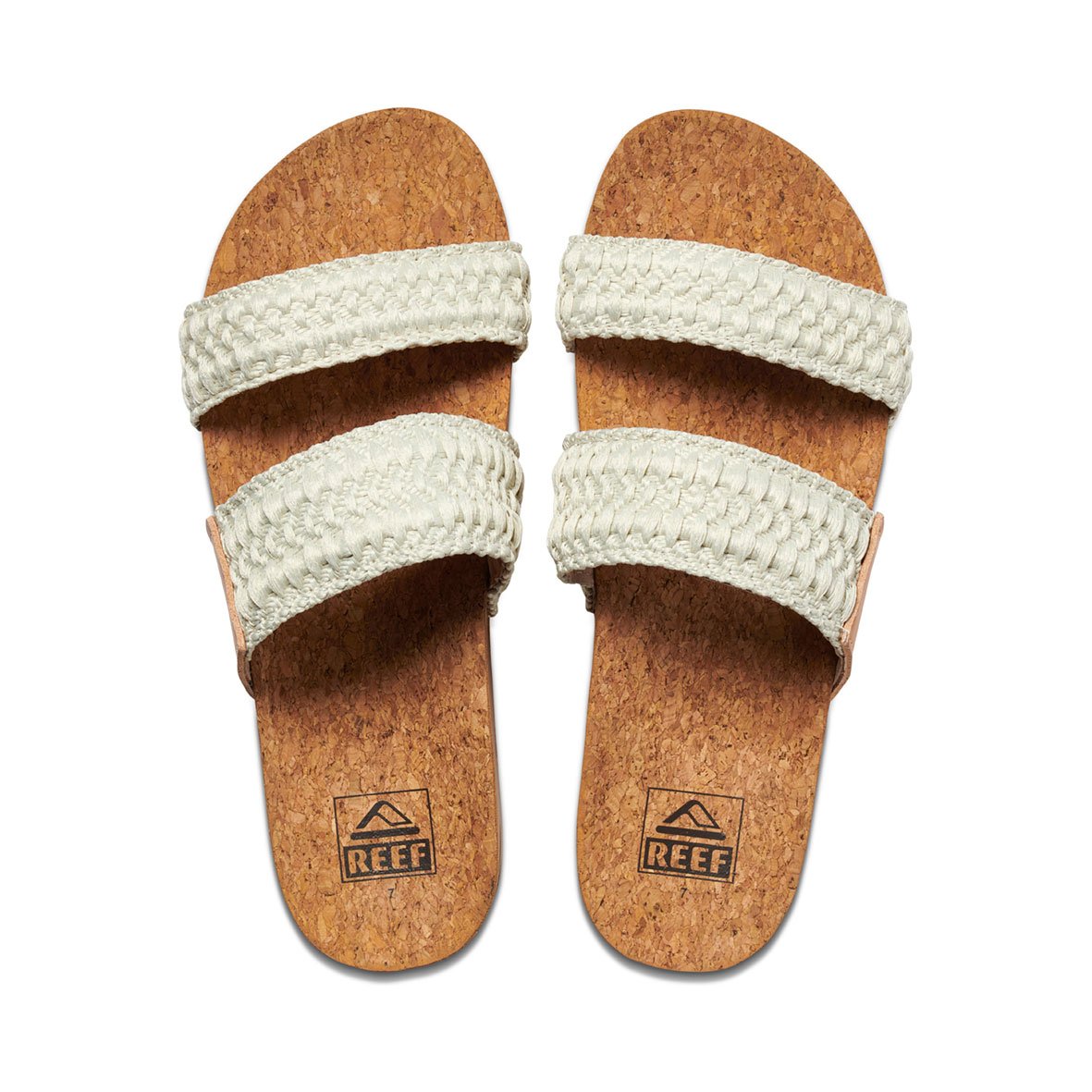 Two REEF Cushion Vista Thread sandals with cork soles display the brand logo, featuring two wide cream-colored woven straps and cushioned EVA foam, are shown side by side on a white background.