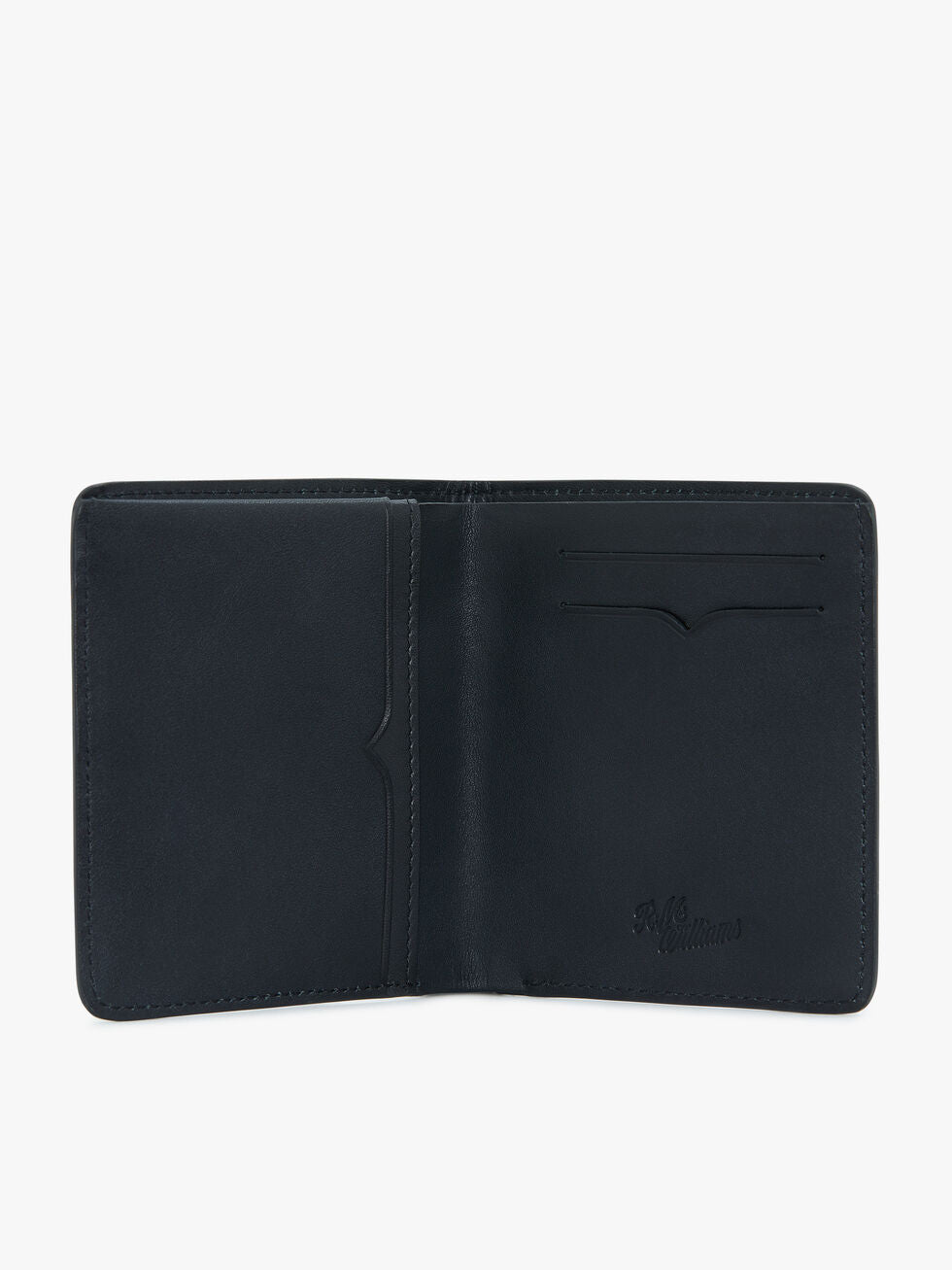 The RM Williams Urban Bi-Fold wallet, crafted from full grain leather, features multiple compartments including a large pocket on the left and two card slots on the right. The inside boasts a subtle embossed signature near the bottom right corner. The wallet is set against a plain white background.