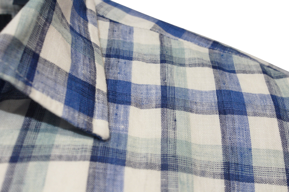 Close-up of the Back Bay Linen Check Short Sleeve Shirt, highlighting the collar and shoulder. The stylish fabric showcases a blue and white plaid pattern with intersecting shades of blue lines, enhancing its modern appeal.