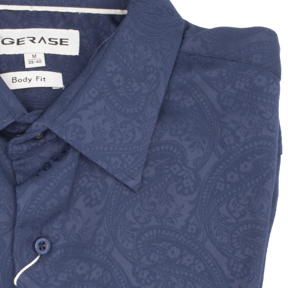 Close-up of a folded Gerase Paisley Print Dress Shirt, featuring branded labels and a striking paisley design. This medium-sized (39-40) Body Fit shirt is crafted from soft Bamboo Fibre and neatly buttoned up.