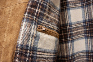 A close-up of the Daniel Hechter Suede Jacket showcases its plaid design with brown, blue, and white squares. It features a diagonal zipper pocket in contrasting brown suede and a soft, wool-like texture.