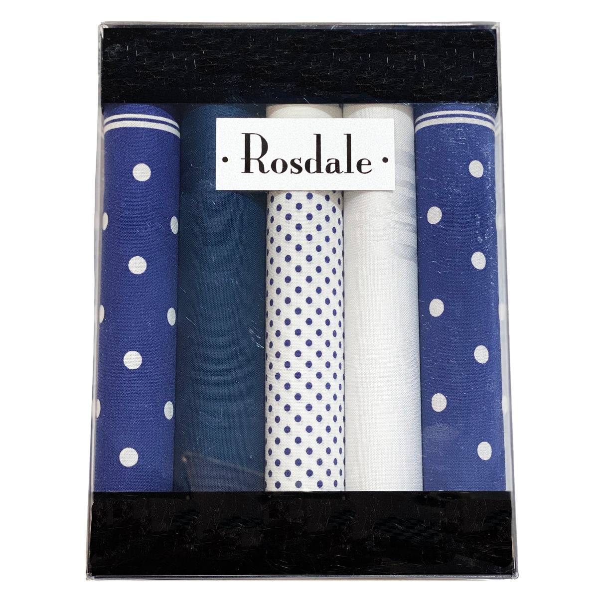 The Rosdale Traditional Hankies 5pk is a boxed set containing five 100% cotton handkerchiefs in various designs: one with large white polka dots on a dark blue background, one solid dark blue, one with small blue polka dots on a white background, and two solid white. The brand "Rosdale" is labeled on the box—a perfect gift for men.