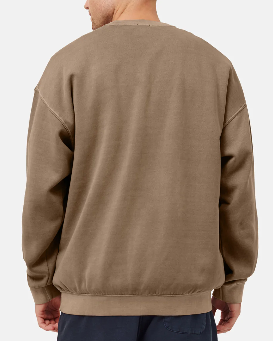 Seen from the back, a person wears the oversized Industrie The Del Sur Sweat in brown, with cozy fleece lining, paired with dark pants against a plain light gray background.