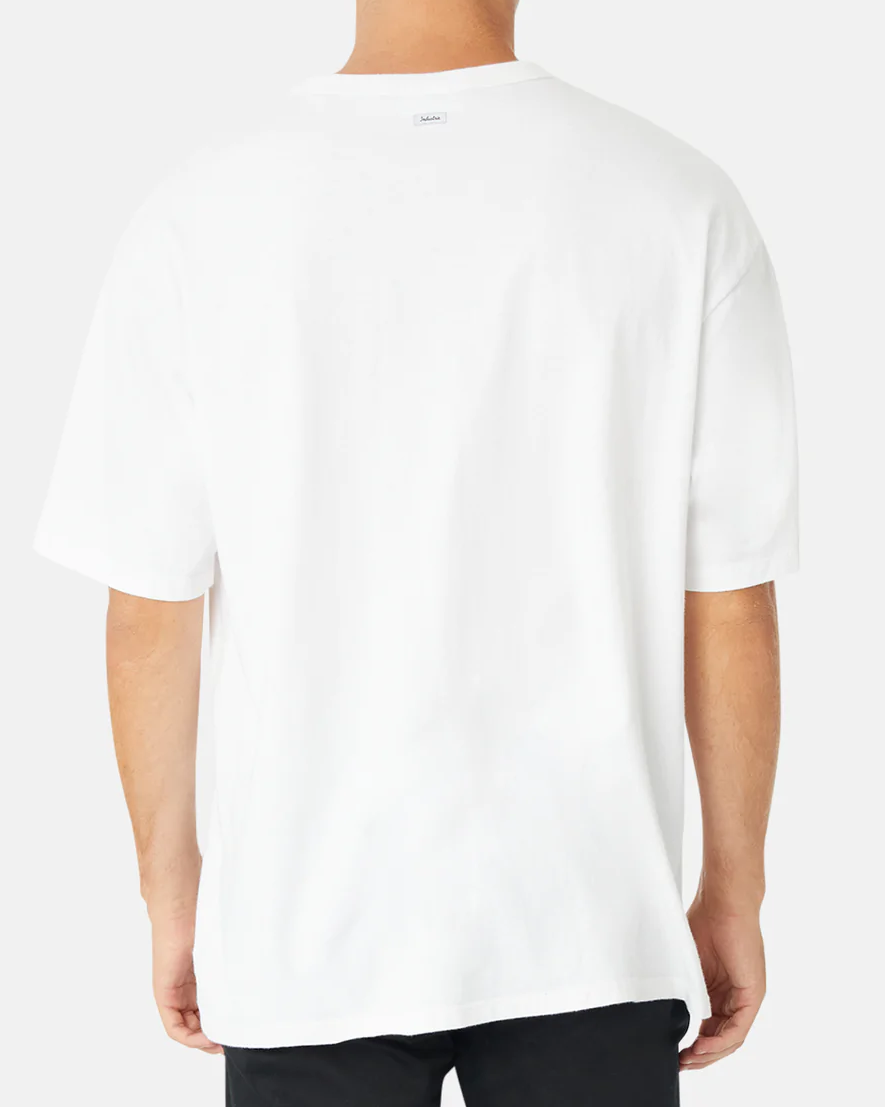 A person wearing the Industrie The Del Sur Tee, a loose-fitting oversized 100% cotton T-shirt with short sleeves, and black pants stands against a light gray background, facing away from the camera.