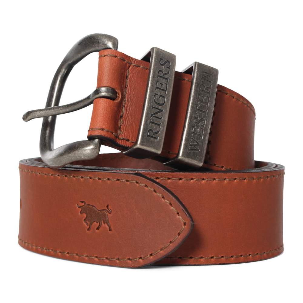 The Ringers Western James Belt is a genuine leather accessory with a metallic buckle, showcasing two metal tags embossed with "RINGERS" and "WESTERN." This Australian Made belt is stamped with the silhouette of a bull at the end, epitomizing its Ringers Western heritage.