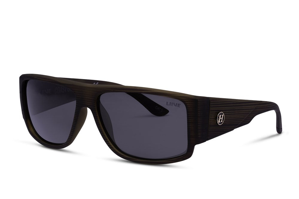 A pair of sleek Liive Coast Guard Polar Sunglasses featuring dark, oversized rectangular lenses and wide black and brown striped frames. The UV-protection arms are adorned with a small circular emblem bearing the letter "H," adding a touch of elegance.