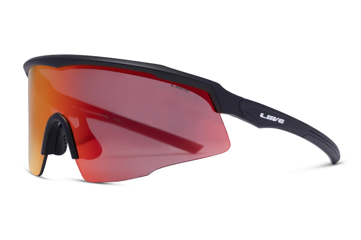 Liive Dealer Mirror Sunglasses feature a sleek black design with curved frames and orange-tinted mirror lenses. Made of durable polycarbonate, they provide UV protection. The frames include a rubberized nose pad, and the brand logo is on the temple.