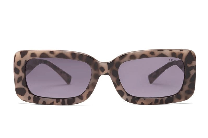 Introducing Liive Crush Sunglasses: These rectangular shades feature a striking leopard print frame paired with dark tinted lenses. The arms of the sunglasses continue the bold leopard pattern all the way to the back. Crafted from lightweight polycarbonate, they ensure UV protection for your eyes. The background is plain white.