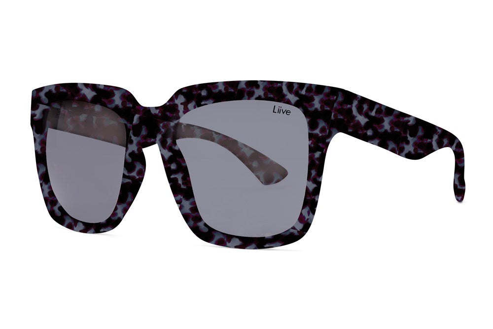 The Liive Layla Sunglasses include large, square-shaped polycarbonate lenses and a frame with a dark, mottled pattern featuring shades of black, white, and hints of purple. Offering excellent UV protection, the left lens is inscribed with "Liive" near the top corner.