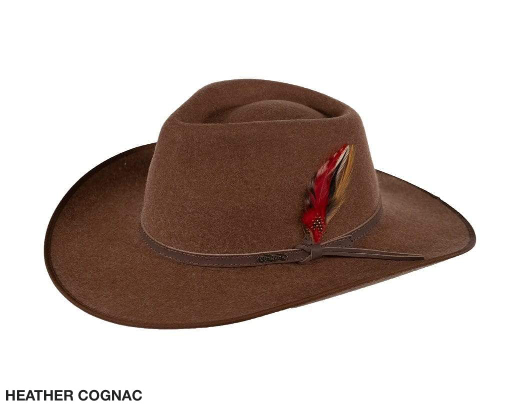 A brown wool cowboy hat with a wide brim, similar to the Outback style, features a decorative red feather in the band and is slightly tilted forward. Text at the bottom reads "HEATHER COGNAC." Product: Outback Cooper River Wool Hat.