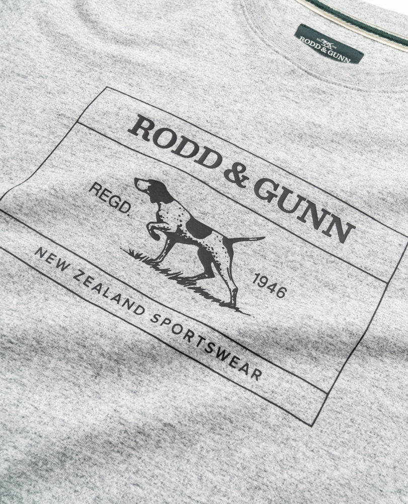 The Rodd & Gunn Bonny Glen Sports Fit T-Shirt has a black dog graphic with "RODD & GUNN," "REGD," "1946," and "NEW ZEALAND SPORTSWEAR" text. Made from 100% cotton, it offers a comfortable sports fit for everyday style.