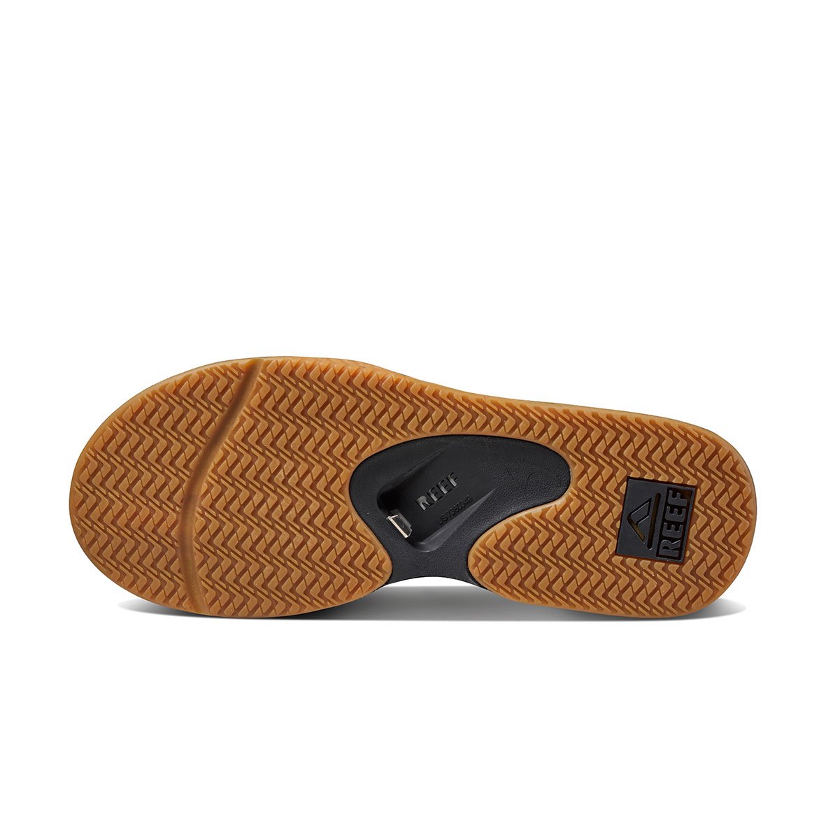 The image displays the sole of the REEF Fanning shoe with a brown, textured herringbone pattern. A black section features "REEF" and the logo. The design includes diverse ridges for grip and a concealed bottle opener for added functionality.