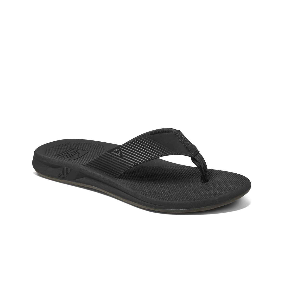 The REEF Phantom II is a black flip-flop sandal featuring a textured sole and supportive thongs with a fabric strap. The black strap is adorned with subtle diagonal lines in a lighter shade of black and attached to the sole with a single post between the toes. This water-friendly sandal, designed for comfort, rests on a white background.
