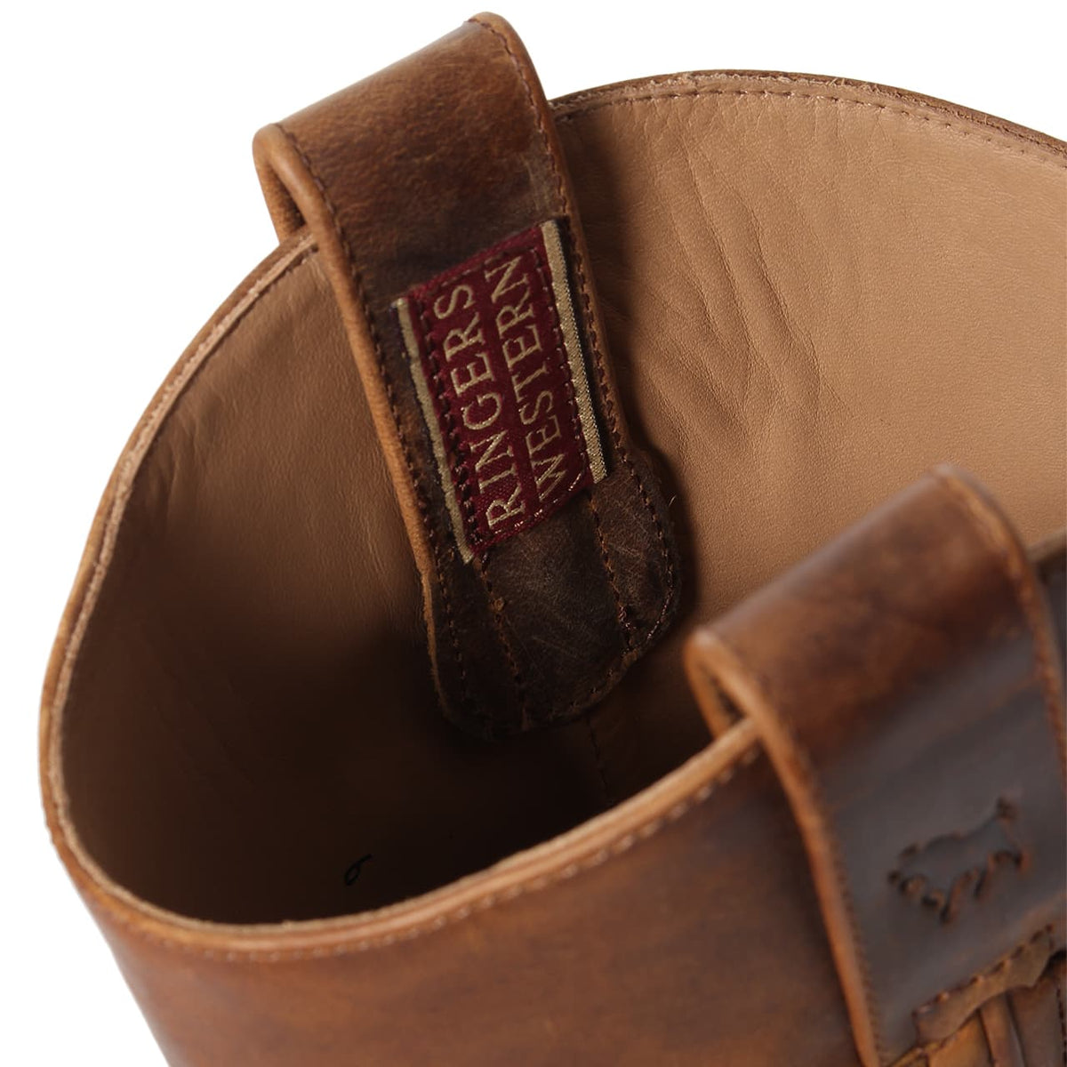 Close-up of the interior of a Ringers Western Kimberley High Boot with visible stitching. A fabric tag reading "RINGERS WESTERN" is sewn onto the inner seam near the top. The texture and details of the genuine leather are clearly seen. The brand's logo is faintly visible on the exterior side.