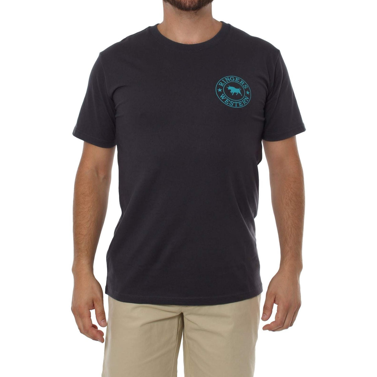 A person wearing the Ringers Western Signature Bull Classic T-Shirt in navy blue, featuring a turquoise-colored logo on the left chest that showcases a cow surrounded by the text "Ringers Western." They are also dressed in beige pants with their hands relaxed by their sides, all set against a plain white background that highlights this comfortable T-shirt.