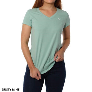 A woman wears the Ringers Western Signature Bull Relaxed V-Neck T-Shirt in dusty mint green with a small white chest logo and dark jeans, standing against a plain white background.
