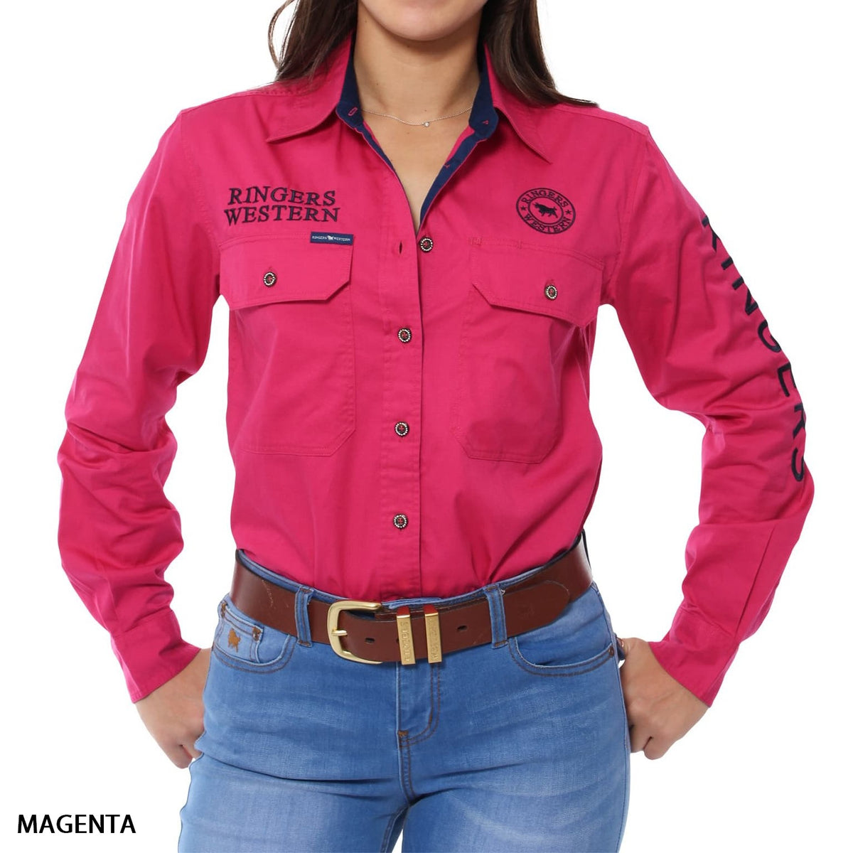 A woman wears the Ringers Western Signature Jillaroo Womens Full Button Shirt in bright magenta with UPF50+, "Ringers Western" logo and text, front pockets, right sleeve lettering, paired with blue jeans and a brown belt. 100% cotton.