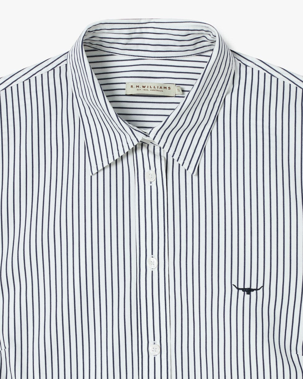 The RM Williams Nicole Shirt is a white, 100% cotton long sleeve shirt with thin vertical black stripes, an embroidered black chest logo, and a visible R.M. Williams label inside the collar.
