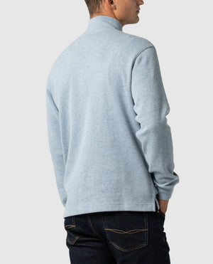 A person is shown from the back, wearing the Rodd & Gunn Alton Ave Sweat, a light blue long-sleeve turtleneck sweater made of 100% cotton, paired with dark jeans against a plain light gray background.