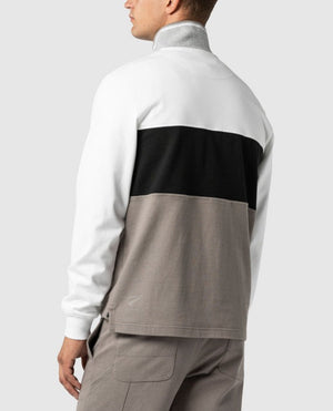 A man is shown from the back wearing a 100% Cotton Hillop Sweat by Rodd & Gunn, which features color-block sections in white, black, and gray. He pairs it with matching gray pants against a plain light gray background. This ensemble exudes a timeless elegance reminiscent of a stylish jumper by Rodd & Gunn.