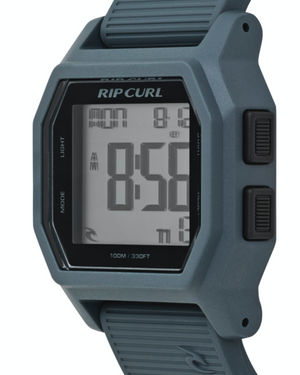 The Rip Curl Atom Digital Watch in gray shows 8:58 AM on its rectangular screen, has side buttons for mode and light, and is water resistant up to 100 meters (330 feet).