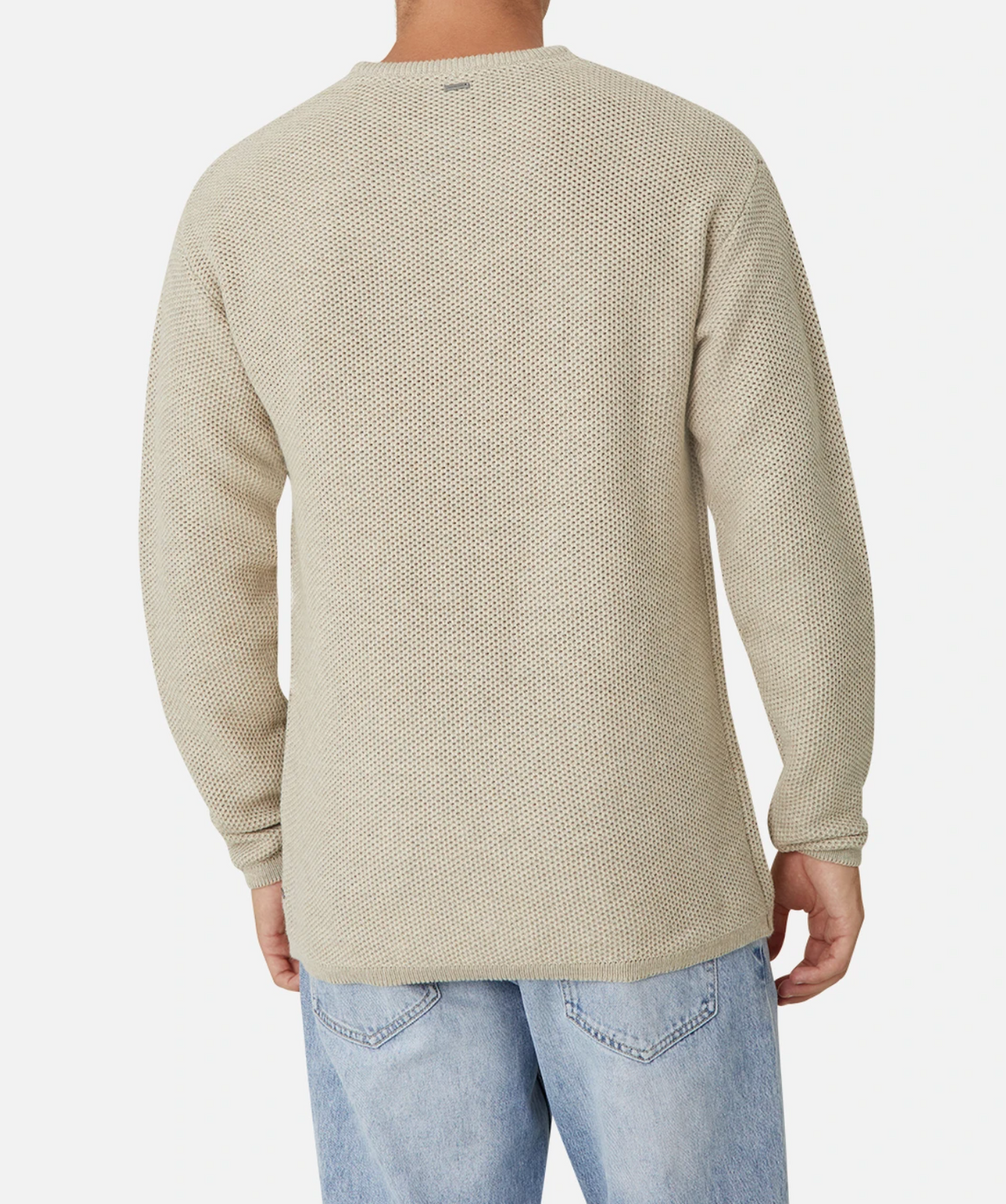 A person is seen from the back, wearing the Industrie The Washed Culver Knit, a stylish and textured light beige 100% cotton sweater with ribbed cuffs and a relaxed fit, paired with light blue jeans. The background is plain white.