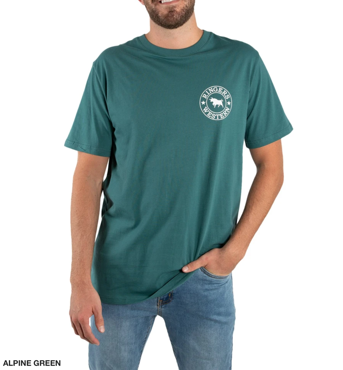 A bearded man casually poses with one hand in his pocket, wearing a Ringers Western Signature Bull Classic T-Shirt in alpine green featuring a circular chest logo, paired with blue jeans.
