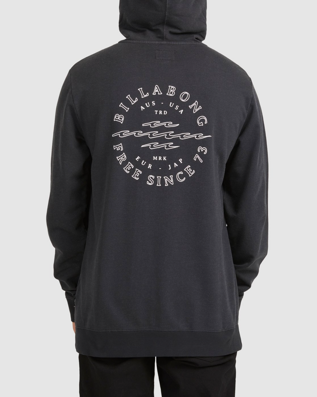 A person seen from the back in a black Billabong Big Wave Dan Hood, featuring a circular white graphic with wavy lines and the text "Billabong Free Since '73" plus country abbreviations.